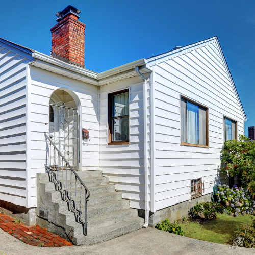 Older single story home with white siding.