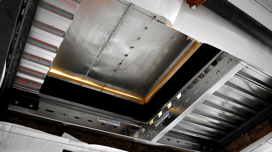 A roof hatch framed with a QuickFrames support structure, providing access through the metal decking and insulation layers.